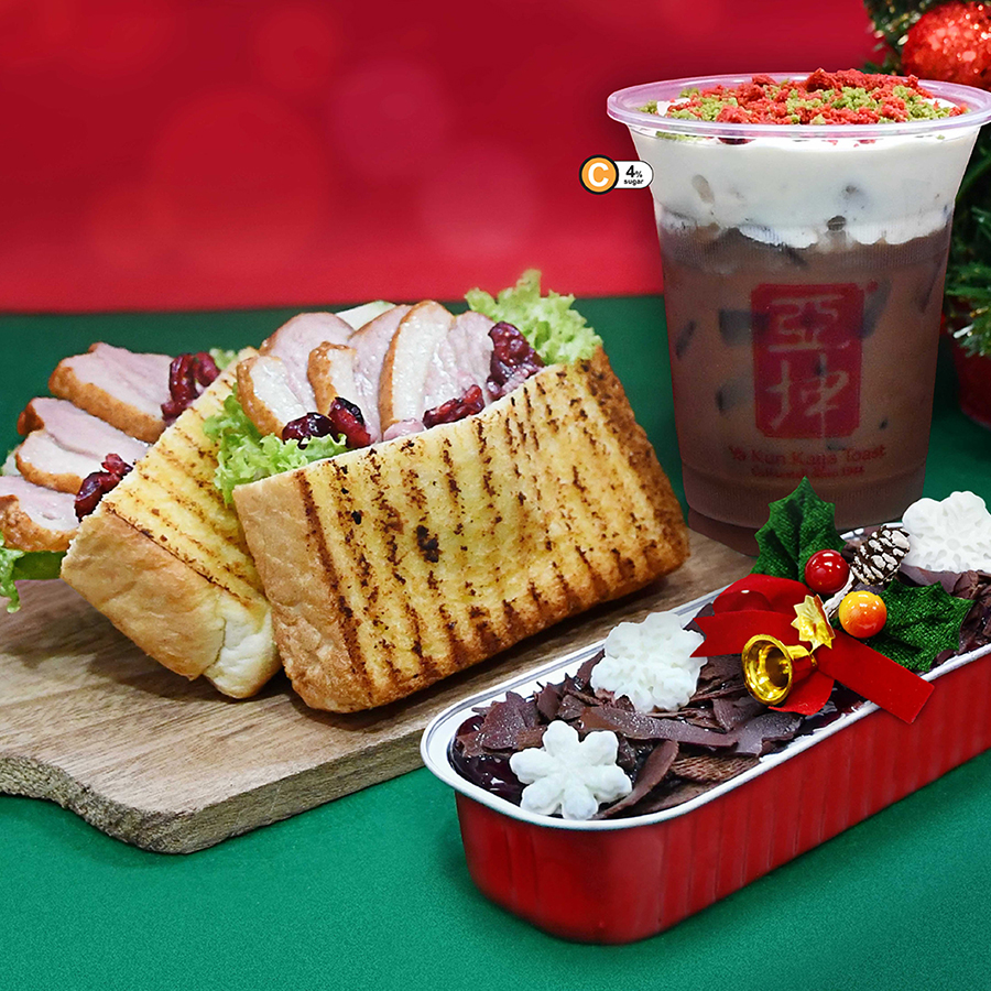 A spread of Ya Kun Kaya Toast's festive offerings, including a cranberry smoked duck toastwich, iced chocolate cheese foam, and black forest cheesecake.